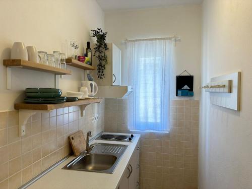 a small kitchen with a sink and a window at Guest House KovacevicA in Hvar