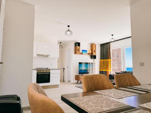 a kitchen and dining room with a table and chairs at Thalassa Beach Resort 2 Bedroom Penthouse with a Hot Tub in Vokolidha