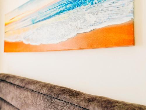 a painting hanging on a wall above a couch at Thalassa Beach Resort 2 Bedroom Penthouse with a Hot Tub in Vokolidha