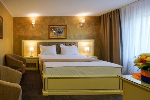 a hotel room with a bed and two chairs at Hotel Bulevard in Constanţa