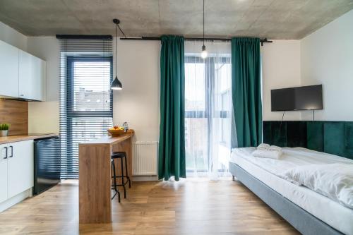 a bedroom with a large bed with green curtains at Apartamenty Silver Place in Szczecin