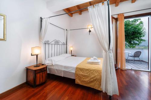 a bedroom with a canopy bed and a window at Locanda Da Vittorio in Manerba del Garda