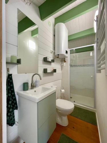 une salle de bain blanche avec des toilettes et un lavabo dans l'établissement La Paix, Chalet de charme dans le Bocage Normand, à Condé-sur-Noireau