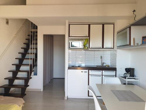 une cuisine avec des placards blancs et un escalier dans l'établissement Appartement climatisé à 800m de la plage, à Fréjus