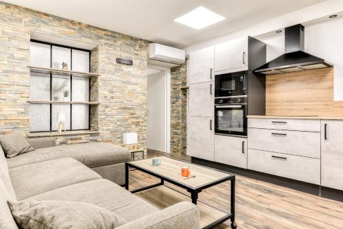 un salon avec un canapé et une table dans l'établissement Côté Palais avec Climatisation - Fibre & Netflix - Spacieux en rez-de-chaussée, à Carcassonne