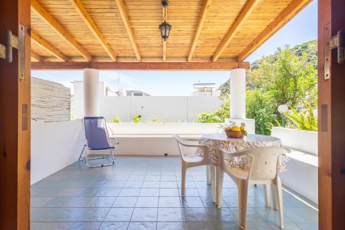 un patio con mesa y sillas en un porche en Hotel Residence La Villetta, en Canneto