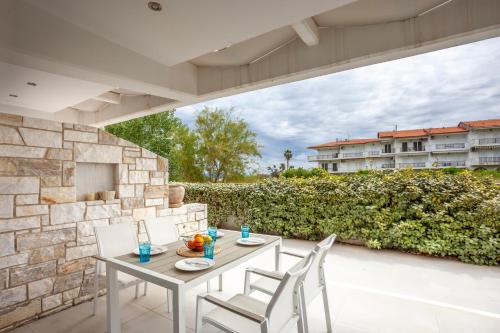 a table and chairs on the patio of a building at Villa Hanioti Dream seafront in Hanioti
