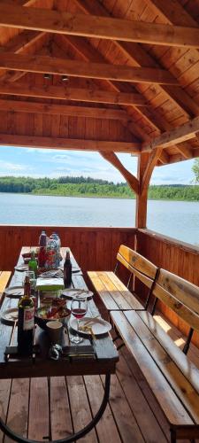 - une table de pique-nique sur une terrasse en bois sur un bateau dans l'établissement Tatarak domki na mazurach nad jeziorem Wałpusz, domek nr 3, 4, à Stare Kiejkuty