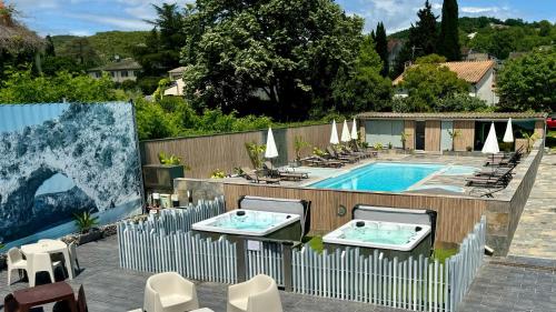 - une piscine avec 2 chaises et une clôture dans l'établissement Logis Hôtel Restaurant Bellevue, à Saint-Martin-dʼArdèche