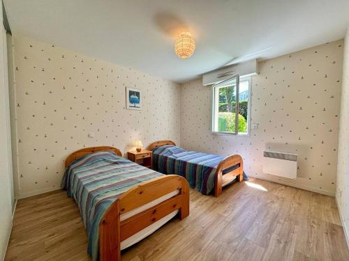 une chambre avec deux lits et une fenêtre dans l'établissement Appartement 3 pièces Carnac – RDC avec terrasse, jardin, proche plage et commerces - FR-1-377-5, à Carnac