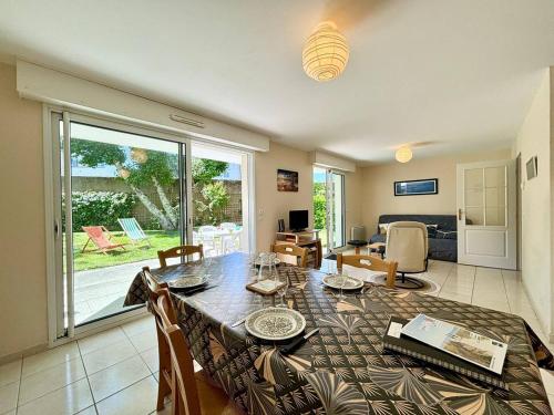 un salon avec une table à manger et un salon dans l'établissement Appartement 3 pièces Carnac – RDC avec terrasse, jardin, proche plage et commerces - FR-1-377-5, à Carnac