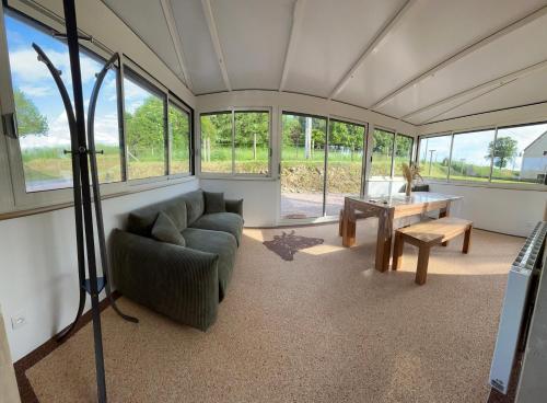 a living room with a couch and a table at Au pré des acajous in Pertheville-Ners