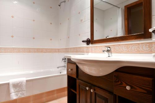 uma casa de banho com um lavatório, um espelho e uma banheira em Cornucopia Hotel em Xaghra