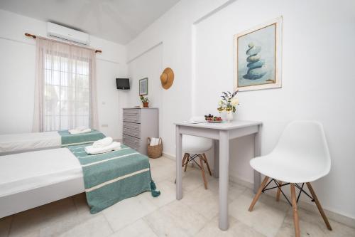 um quarto com uma cama, uma mesa e uma secretária em Hippocampus studios 2 min walk from the beach em Moutsoúna