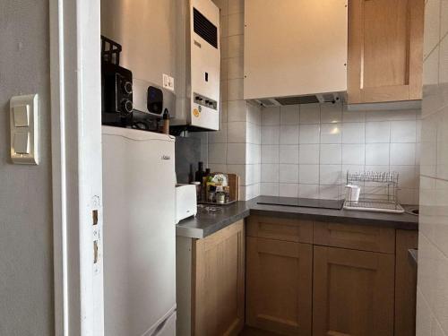 Elle comprend une petite cuisine équipée d'un réfrigérateur blanc et de placards. dans l'établissement Studio à 5 min de la plage des Elmes avec parking, ascenseur - 2 pers. - FR-1-225C-125, à Banyuls-sur-Mer