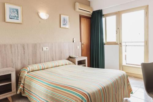una camera d'albergo con letto e finestra di Hotel Camposol a Benidorm