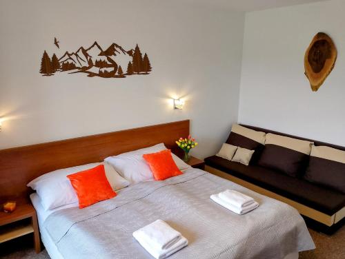 a bedroom with a bed with orange and white pillows at Tatry PANORAMA apartmány Tatragolf B-F in Veľká Lomnica