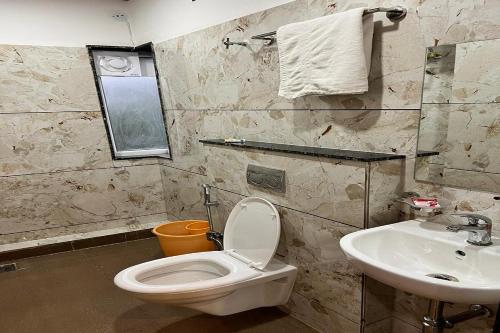 y baño con aseo y lavamanos. en Hotel Sarika International, en Indore