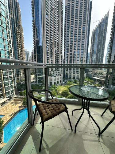 a balcony with a table and chairs and a view of a city at The residences 1 - Luxury 1BR apt in Downtown Dubai - 2 mins walk to Burj Khalifa & Dubai Mall in Dubai