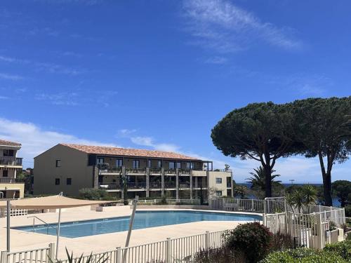une grande piscine devant un immeuble dans l'établissement Appartement T2 avec piscine et vue mer proche plages - FR-1-768-76, aux Issambres
