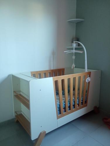 a baby crib with a lamp in a room at Couleur pastel in Saint-Louis