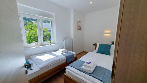 a small bedroom with two beds and a window at Apartments Seventy Seven in Kranjska Gora