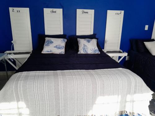 a blue bedroom with a large bed with two pillows at Sweet Dreams Polokwane in Polokwane