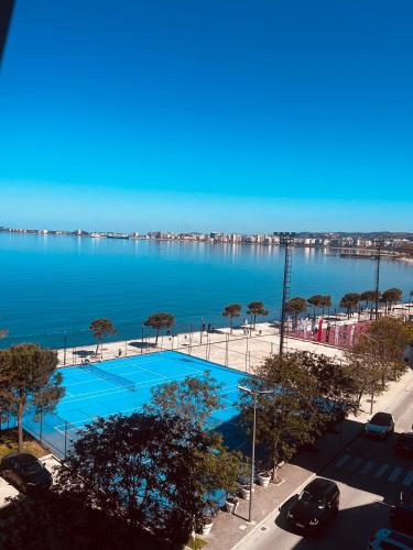 a large blue swimming pool next to a body of water at Hotel Lungomare in Vlorë