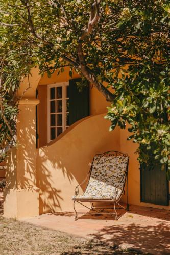 a chair sitting under a tree in front of a building at Hôtel Villa Marie Saint Tropez in Saint-Tropez