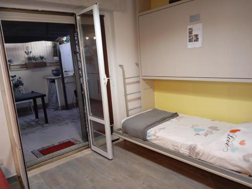 a small bedroom with a bunk bed and a sliding glass door at Appartamento 50 mt dal mare in Lido di Ostia