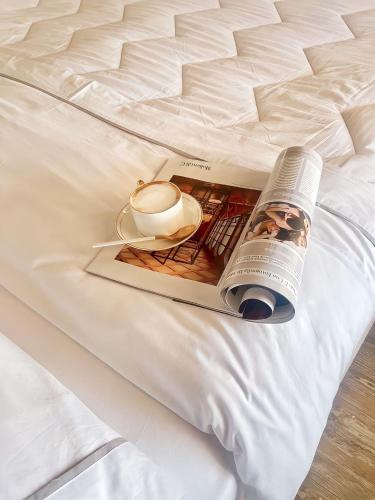 a book on a bed with a lamp and a candle at Hotel Lungomare in Vlorë