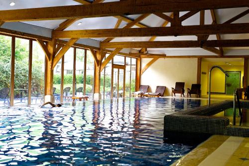 a swimming pool in a building with wooden beams at Luton Hoo Hotel, Golf and Spa in Luton