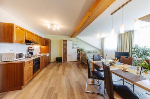 eine Küche und ein Wohnzimmer mit einem Tisch und einem Esszimmer in der Unterkunft Ferienwohnungen Martha in Obersammelsdorf