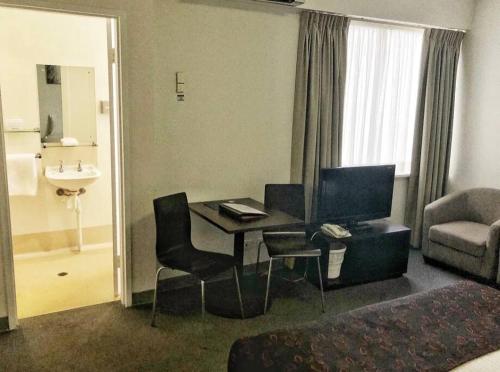 a hotel room with a desk with a computer and a couch at 259 Gouger city unit 105 in Adelaide