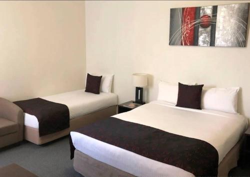 a hotel room with two beds and a couch at 259 Gouger city unit 105 in Adelaide