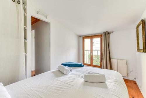 une chambre avec un grand lit blanc avec des serviettes dessus dans l'établissement Le Patio de la Bastide avec Terrasse & Netflix - Quartier paisible, à Carcassonne