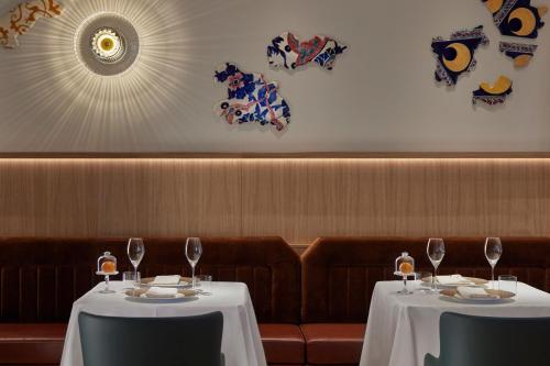 two tables in a restaurant with wine glasses on them at Mandarin Oriental Savoy, Zurich in Zürich