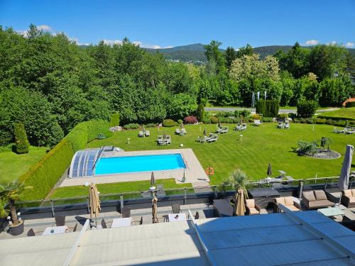 eine Luftansicht auf einen Garten mit einem Pool in der Unterkunft Dei Hotel Schönblick in Velden am Wörthersee
