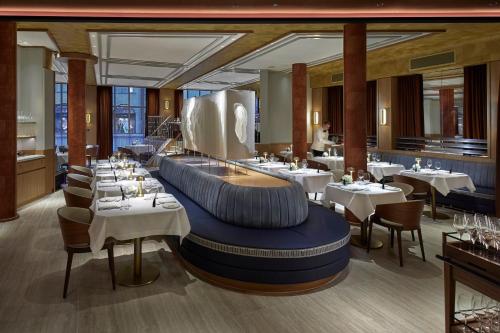 Mandarin Oriental Savoy, Zurich في زيورخ: غرفة طعام مع طاولات وكراسي بيضاء