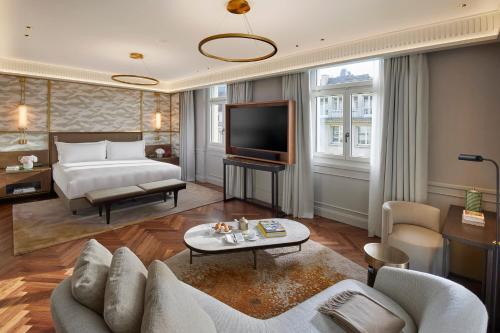 ein Hotelzimmer mit einem Bett und einem TV in der Unterkunft Mandarin Oriental Savoy, Zurich in Zürich