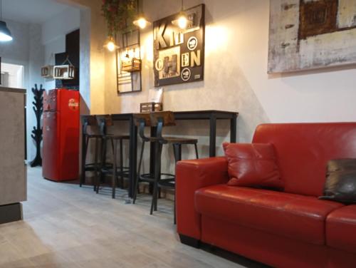 a living room with a red couch and a bar at Appartamento 50 mt dal mare in Lido di Ostia