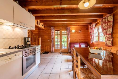 une cuisine avec une table et un comptoir dans l'établissement Chalet indépendant 3 personnes, à Alex