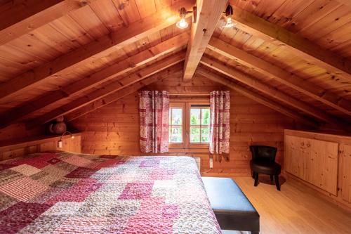 ein Schlafzimmer mit einem Bett in einem Holzhaus in der Unterkunft Chalet indépendant 3 personnes in Alex