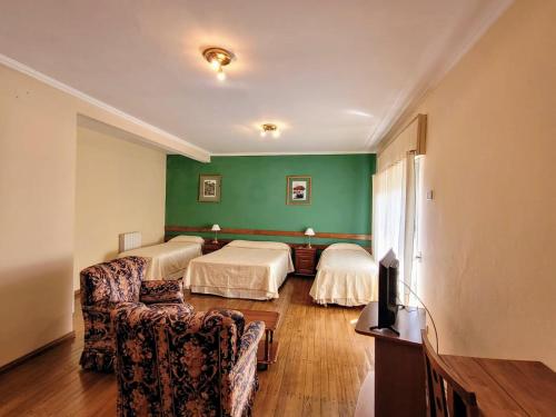 a hotel room with two beds and a couch at Manantiales Hotel Boutique in Victoria