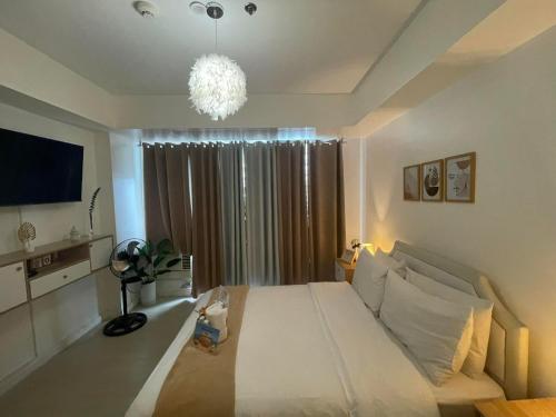 a bedroom with a large white bed and a window at Azure Urban Resort Residences - Staycationary Miami 1210 in Manila