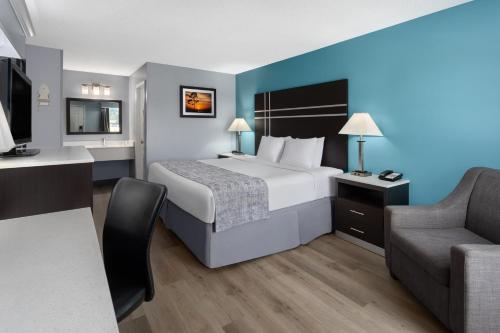 Habitación de hotel con cama y sofá en Baymont by Wyndham Brunswick GA, en Brunswick