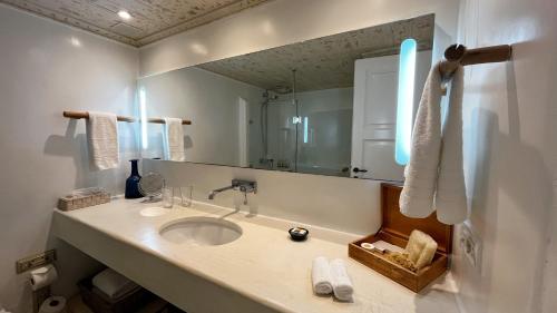 伊莫洛維里的住宿－Iconic Santorini, a Boutique Cave Hotel by Sandglass，一间带水槽和镜子的浴室