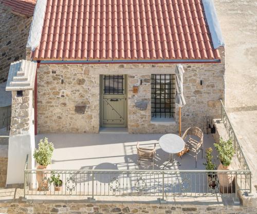 a house with a balcony with a table and chairs at St-Ten Stone Built Village in Áyioi Dhéka