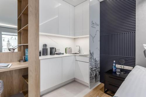 una cocina con armarios blancos y una pared en blanco y negro en Deo Plaza - Apartamenty Old Town by Rent like home, en Gdansk