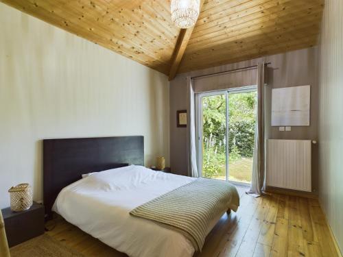 une chambre avec un grand lit et une grande fenêtre dans l'établissement Piscine et sérénité pour votre séjour à Lanton, à Lanton